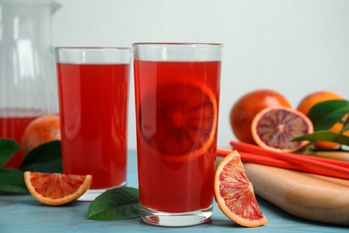 Tasty sicilian orange juice and fruits on light blue wooden table