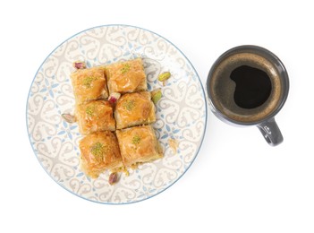 Delicious baklava with pistachios and hot coffee on white background, top view