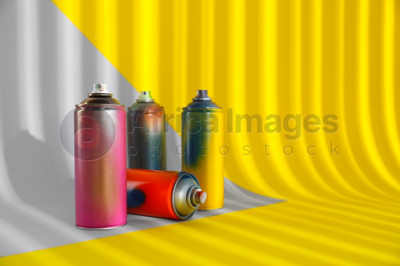 Photo of Used cans of spray paints on color background. Space for text