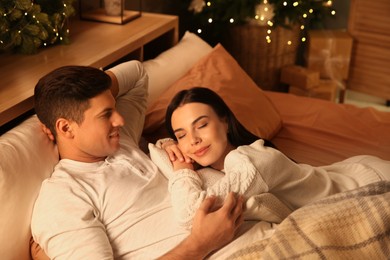 Happy couple in bed at home. Christmas celebration