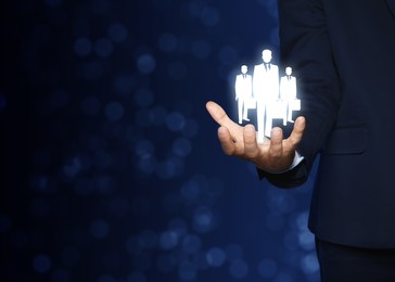 Man presenting virtual icons of businesspeople on dark background, closeup view with space for text. Leadership concept