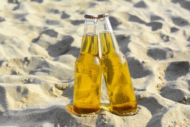 Bottles of cold beer on sandy beach