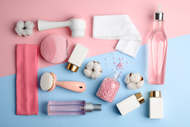 Flat lay composition with face cleansing brushes on color background. Cosmetic tools