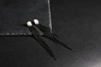 Elegant earrings on black background, space for text. Luxury jewelry
