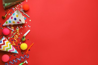 Beautiful flat lay composition with festive items on red background, space for text. Surprise party concept