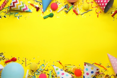 Beautiful flat lay composition with festive items on yellow background, space for text. Surprise party concept