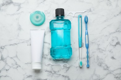 Flat lay composition with mouthwash and other oral hygiene products on white marble table
