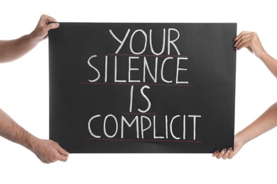 Photo of Man and woman holding sign with phrase Your Silence Is Complicit on white background, closeup. Racism concept