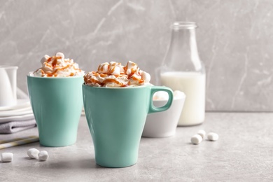 Cups with delicious caramel frappe on table