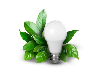 Image of Saving energy, eco-friendly lifestyle. Light bulb and fresh green leaves on white background
