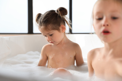 Photo of Cute little sisters taking bubble bath together