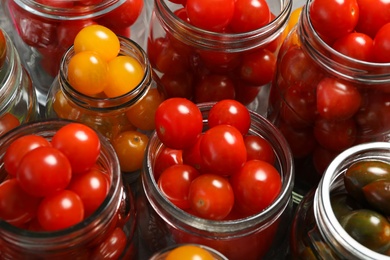 Pickling jars with fresh tomatoes, closeup view