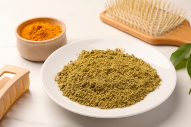 Photo of Henna, turmeric powder and comb on white table. Natural hair coloring