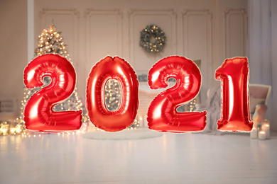 Red foil 2021 balloons in festive room interior 