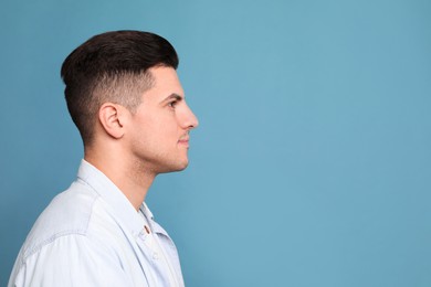 Profile portrait of man on light blue background. Space for text