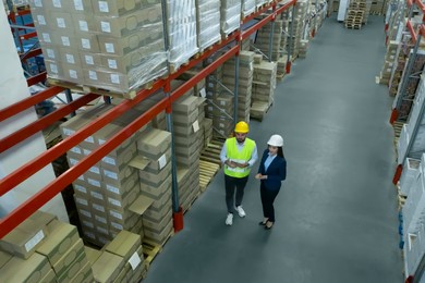 Manager and worker at warehouse, above view. Logistics center