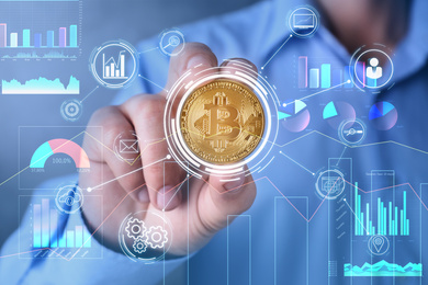 Man holding golden bitcoin on color background, closeup