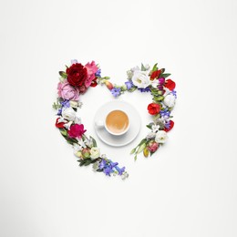 Beautiful heart made of different flowers and coffee  on white background, top view