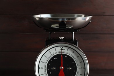Retro mechanical kitchen scale on wooden background, closeup