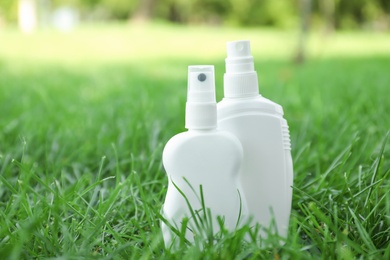Bottles of insect repellent on green grass