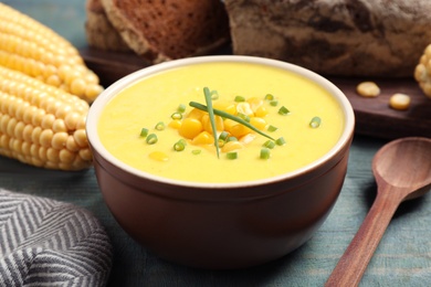 Delicious creamy corn soup served on blue wooden table