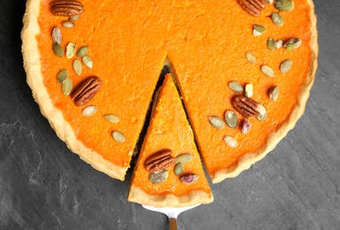 Delicious homemade pumpkin pie on black table, top view