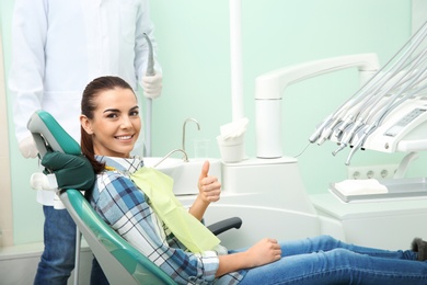 Happy young woman and dentist in modern clinic