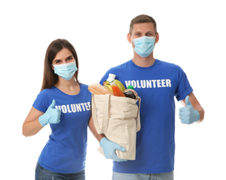 Volunteers in protective masks and gloves with products on white background. Aid during coronavirus quarantine