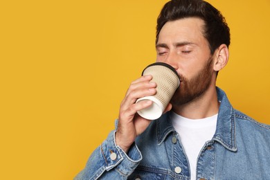 Bearded man drinking coffee on orange background. Space for text