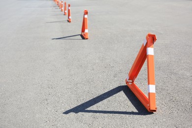 Photo of Triangular parking barriers on asphalt outdoors. Space for text