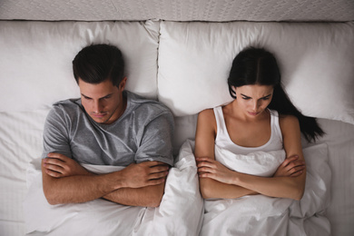 Couple with relationship problems in bed at home, top view