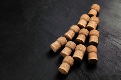 Photo of Christmas tree made of wine corks on dark stone background. Space for text