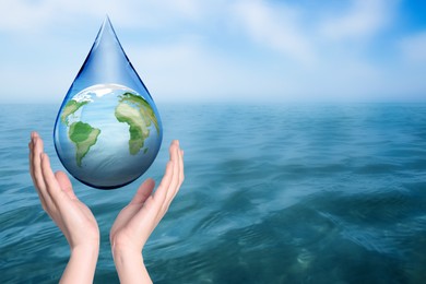 Woman holding icon of Earth in drop near ocean, closeup with space for text. Water save concept
