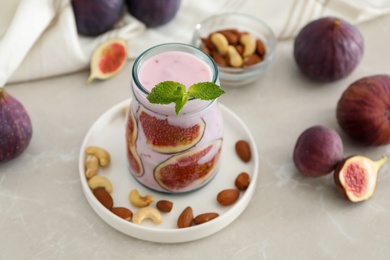 Delicious fig smoothie in glass jar on light table