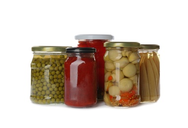 Glass jars with different pickled vegetables and mushrooms on white background