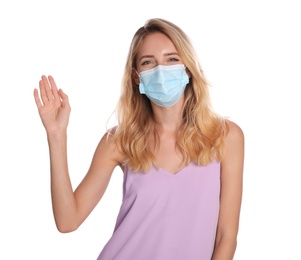 Woman in protective face mask showing hello gesture on white background. Keeping social distance during coronavirus pandemic