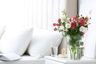 Glass vase with fresh flowers in bedroom