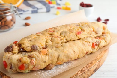 Unbaked Stollen with candied fruits and raisins on white wooden table, closeup