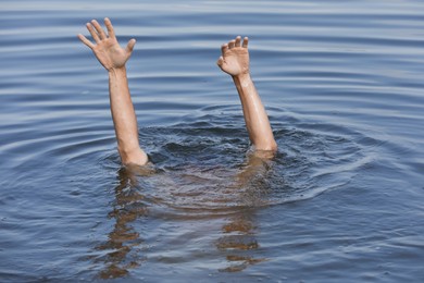 Photo of Drowning man reaching for help in sea, closeup