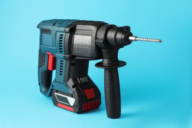 Modern electric power drill on light blue background