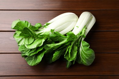 Fresh green pak choy cabbages on wooden table, flat lay