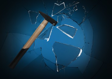 Hammer breaking up glass against black background