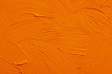 Strokes of orange oil paint as background, closeup