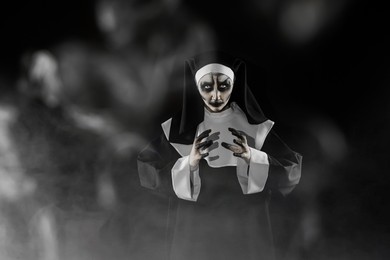 Portrait of scary devilish nun and smoke on black background, space for text. Halloween party look