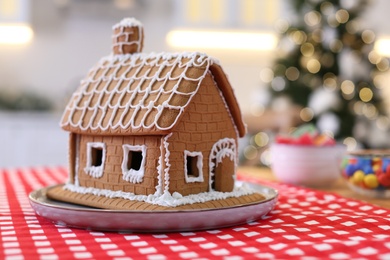 Beautiful gingerbread house decorated with icing on table indoors, space for text
