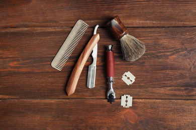 Flat lay composition with shaving accessories for men on wooden background