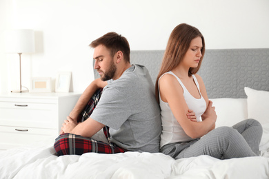 Unhappy couple with relationship problems after quarrel in bedroom