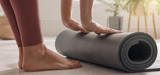 Woman unrolling yoga mat at home, closeup. Horizontal banner design 