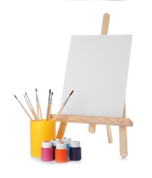 Wooden easel with blank canvas board and painting tools for children on white background