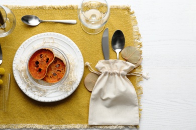 Autumn table setting with dried pumpkin slices on white wooden background, flat lay